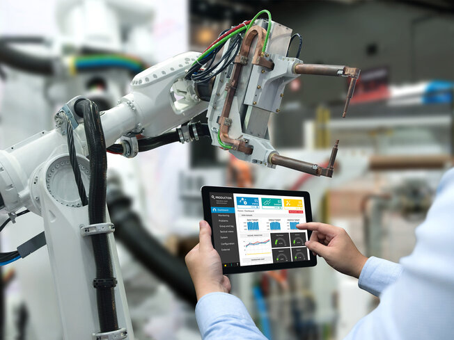 Roboter Arm mit Mitarbeiter und Tablet in der Hand